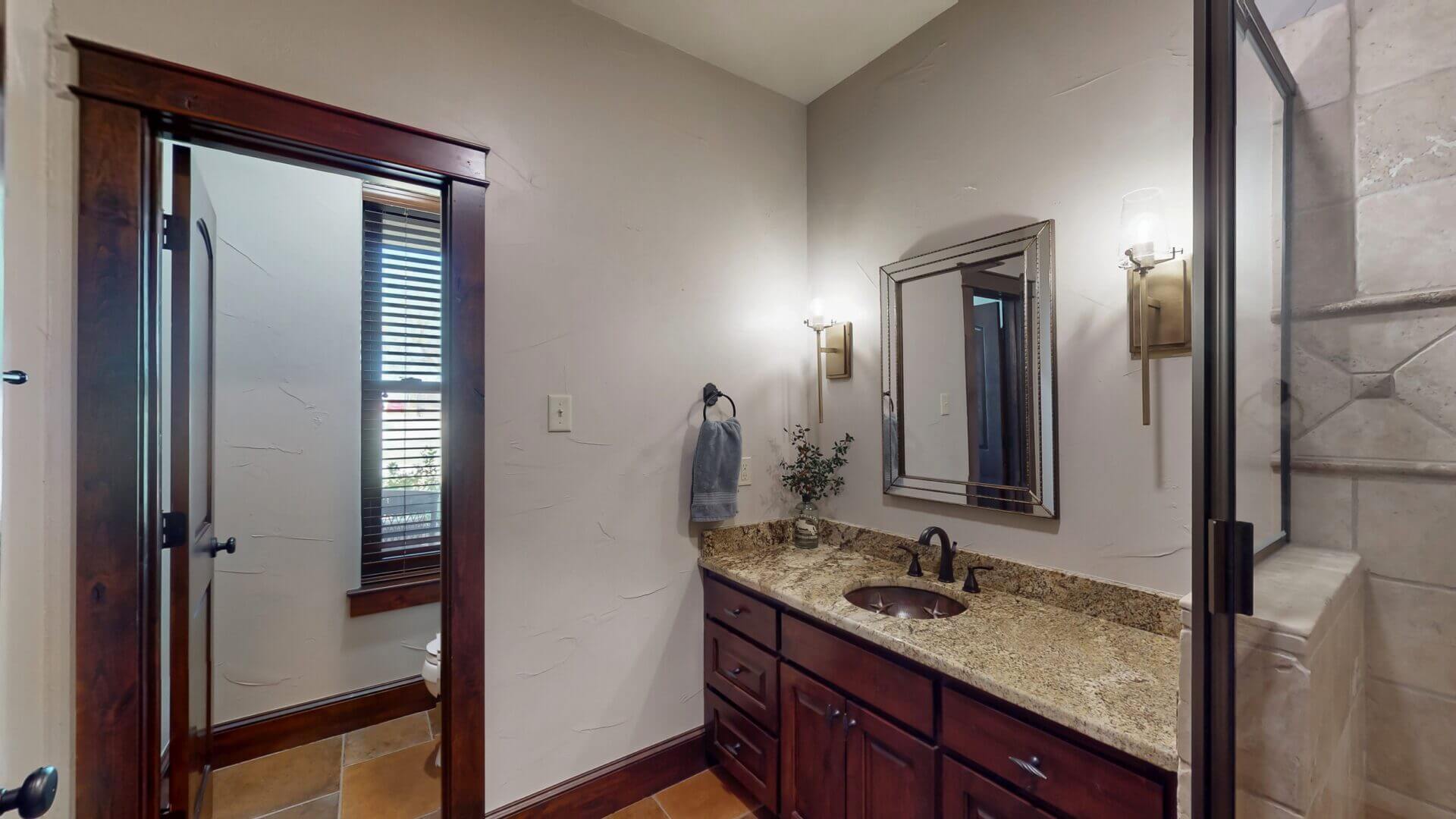 Bathroom with granite countertop and wooden cabinets