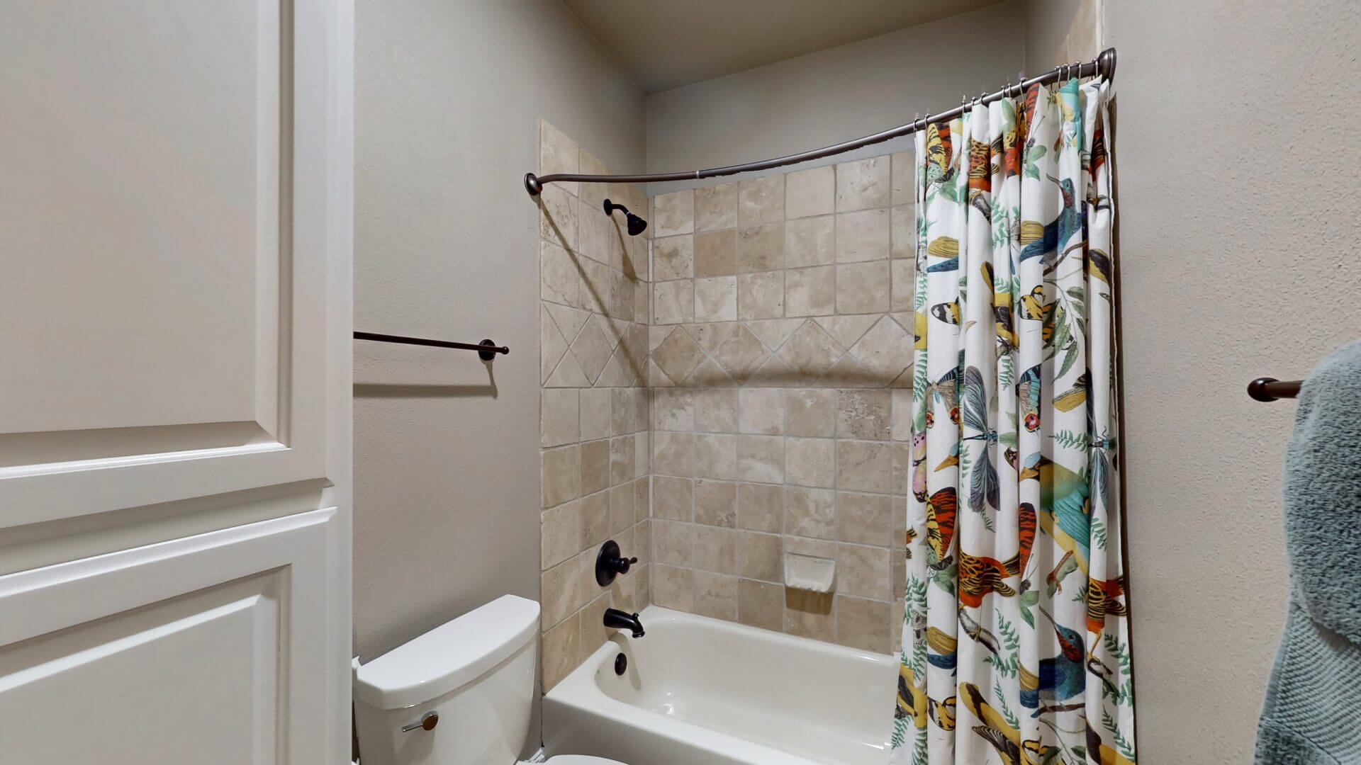 Modern bathroom with bathtub and patterned curtain