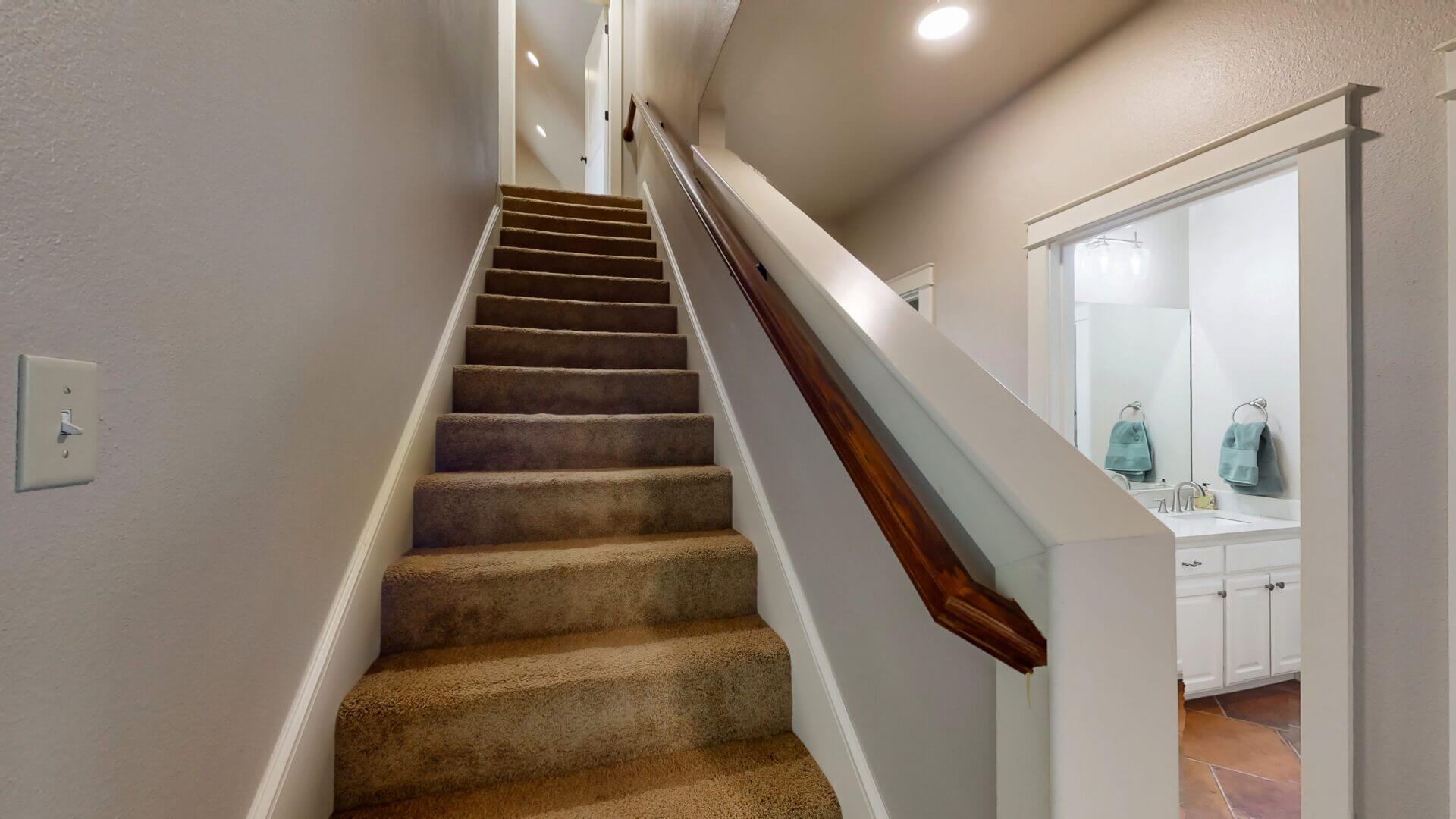 Carpeted stairs leading to upper hallway