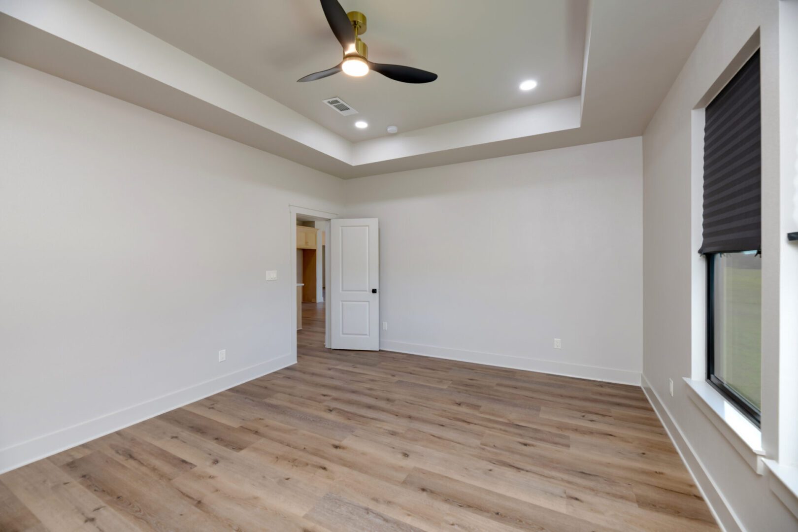 Spacious room with window and light fixture.