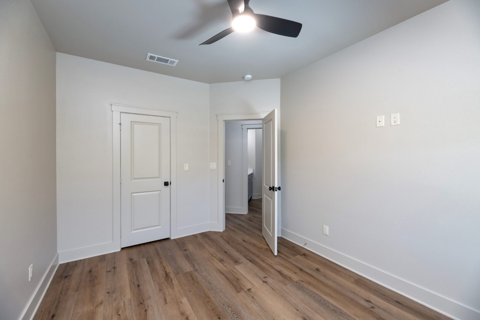 Empty room with wooden floor and fan