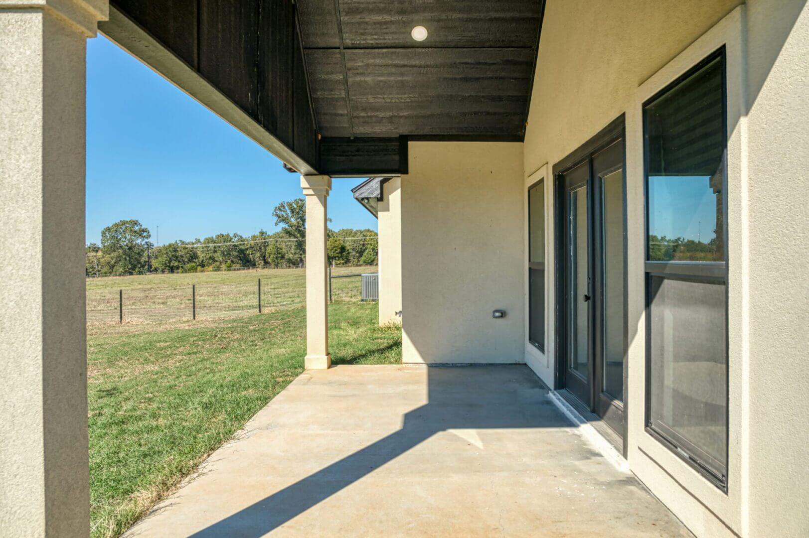 Covered patio with grassy field view