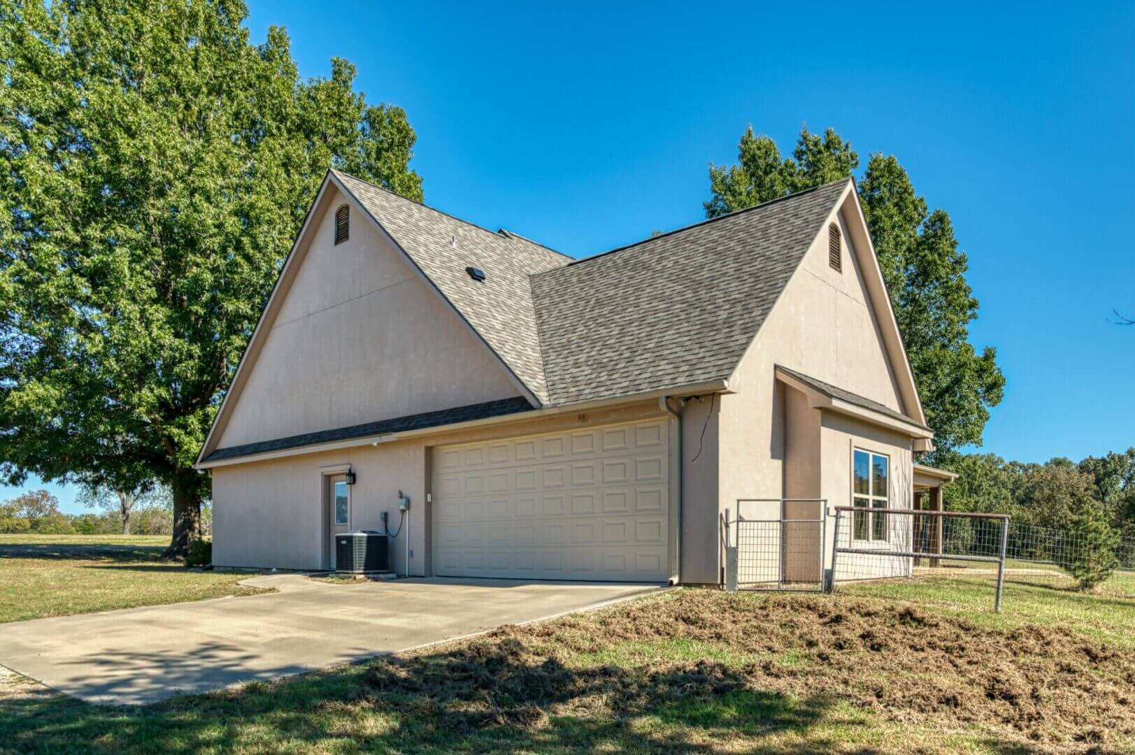 Modern two-story house with a large garage and two people standing outside.