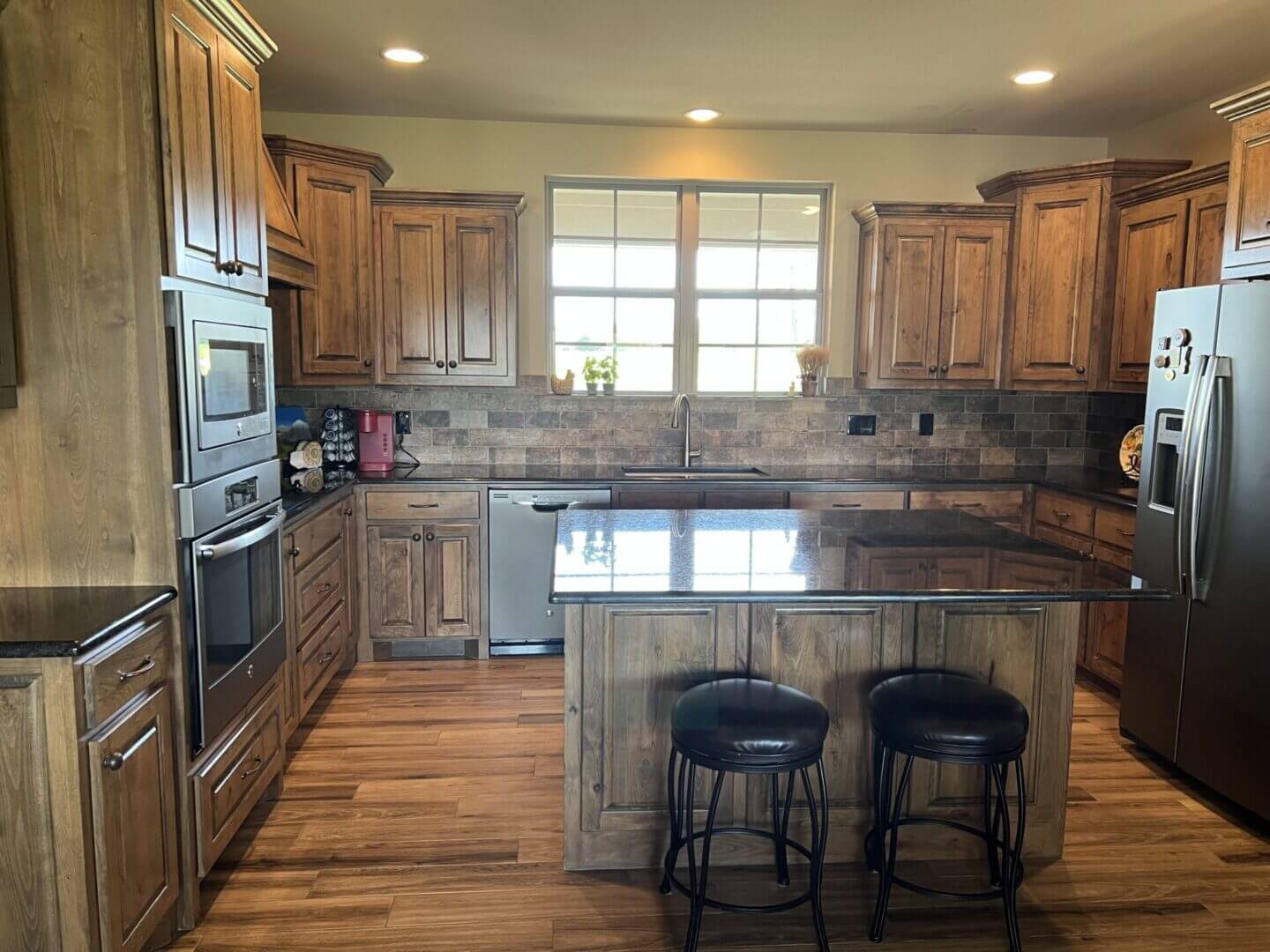 Cozy kitchen with wooden cabinets and a central island with stools.